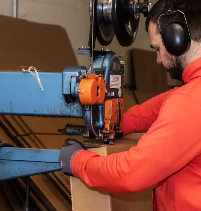 man operates corrugated cardboard drill
