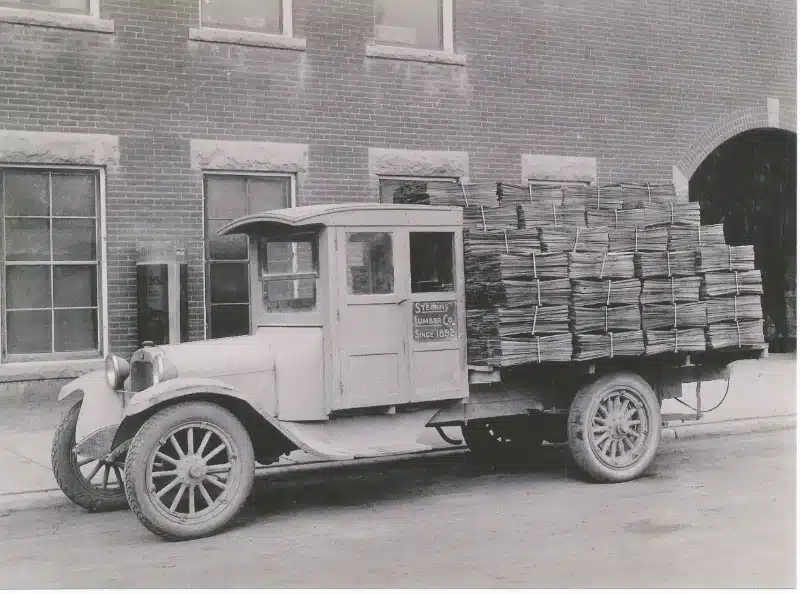 early 1900s stearnswood lumber truck with paper stacks loaded on the back